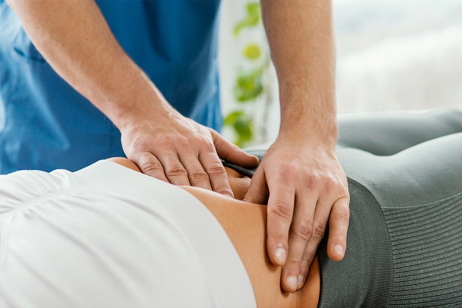 Mani di un osteopata premono su corpo paziente
