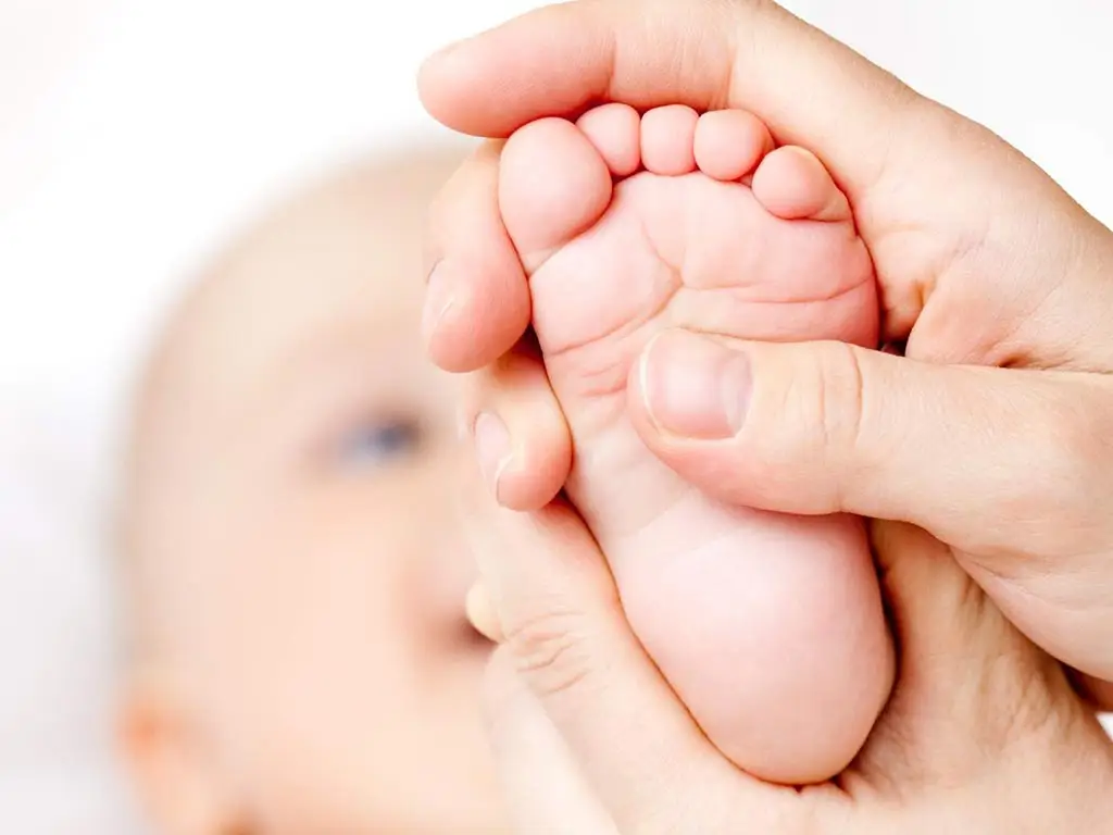 Riflessologia plantare sul piede di un bambino